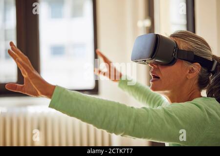 Woman using VR glasses at home Stock Photo