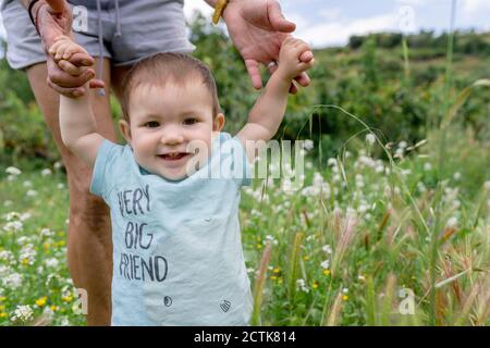 Grandmother holding hands with cute granddaughter in field Stock Photo