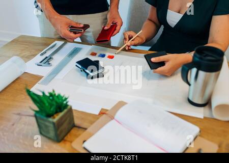 Business professionals working on design at desk in office Stock Photo