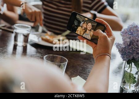 Group of teenage girls meeting for brunch, taking smartphone pictures Stock Photo