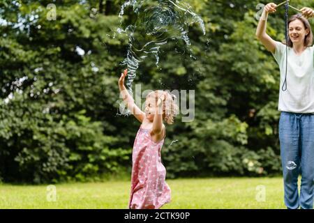 Girl exploding bubble while enjoying at public park Stock Photo