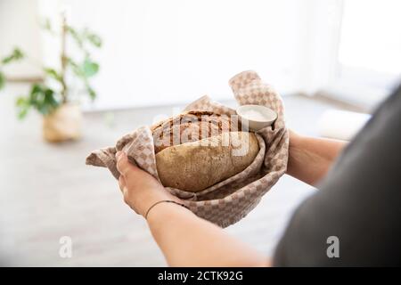 Close-up of mature woman holding bread and salt in new house Stock Photo