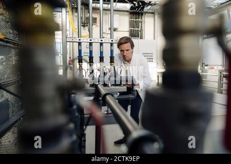 Scientist at pipework in a greenhouse Stock Photo