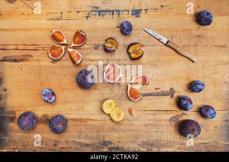 Freshly harvested figs and plums on wooden surface Stock Photo