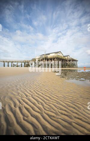 Germany, Schleswig-Holstein, Sankt Peter-Ording, Rippled beach sand with pier in background Stock Photo