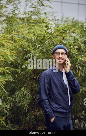 Mid adult man taking on smart phone in public park Stock Photo