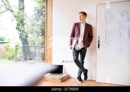 Handsome businessman contemplating while looking through window in office Stock Photo