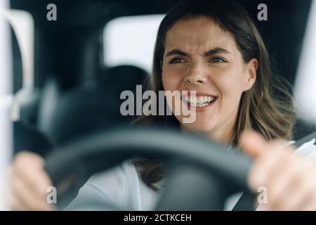 Young woman getting angry while getting stuck in traffic Stock Photo