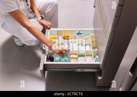 Female doctor searching medicines in drawer at pharmacy Stock Photo