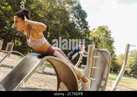 Woman doing push-ups on a fitness trail Stock Photo