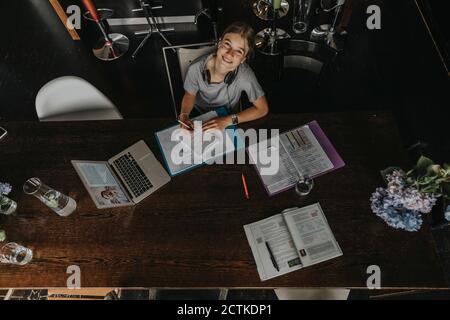 Teenage girl studying from home, using laptop Stock Photo