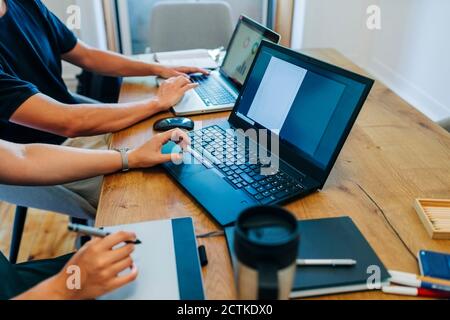 Web designers working while using laptop at office desk Stock Photo