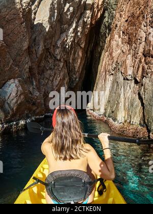 Woman kayaking while sitting in boat during sunny day Stock Photo