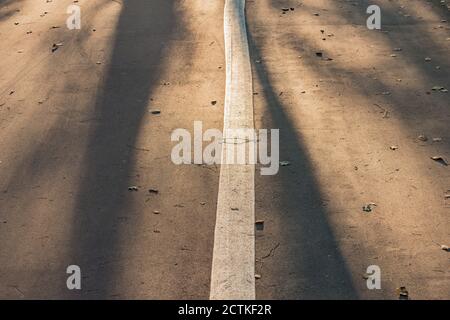 Shadows from the trees on the asphalt road surface. Stock Photo