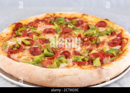 Healthy sized pepperoni and green pepper pizza with thick crust to complete a delicious meal to eat. Stock Photo