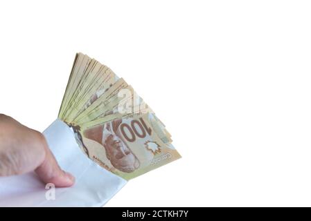 100 dollar canadian bills inside the envelop on white back ground. Stock Photo