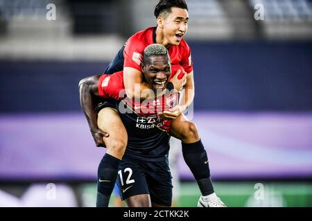 Cameroonian football player John Mary of Shenzhen F.C., front, celebrates after scoring a goal during the fourth-round match of 2020 Chinese Super Lea Stock Photo