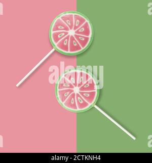 Watermelon lollipops on a pink and green background. Backdrop, banner o background with lollipops and copy space. Top view. Stock Photo