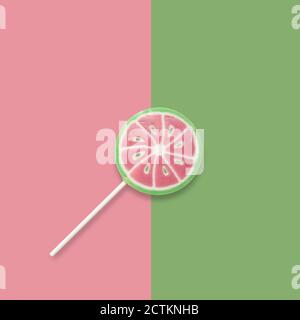 Watermelon lollipop on a pink and green background. Backdrop, banner o background with a lollipop and copy space. Top view. Stock Photo
