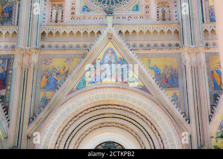 Orvieto, Umbria region, Italy.  Exterior close-up of the front of circa 1330 Orvieto cathedral has a colorful, Gothic facade, divided by four pillars,