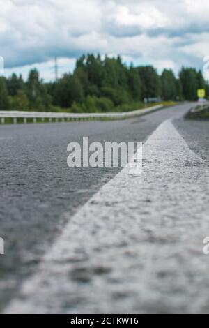 Long white stripe as road markings. The road to the distance. Stock Photo