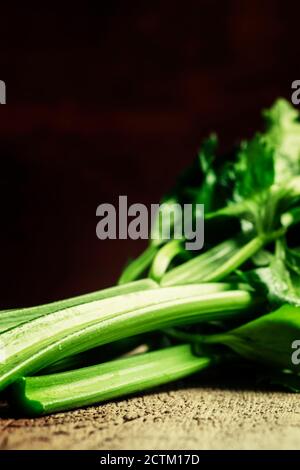 Stems of fresh celery with leaves on the table, vintage wooden background, selective focus Stock Photo