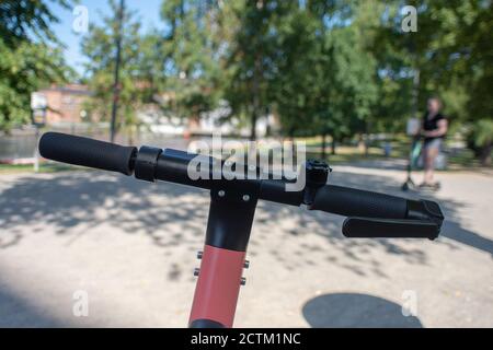 Tampere, Finland - JULY 26, 2019. An alone man riding an electric scooter in public park on a sunny summer day. Stock Photo