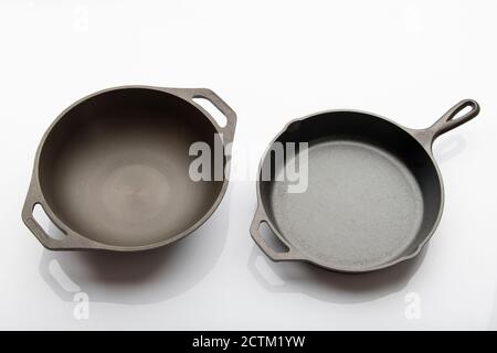 Top View of Seasoned Cast Iron Skillet and Deep Kadai on White Background Stock Photo