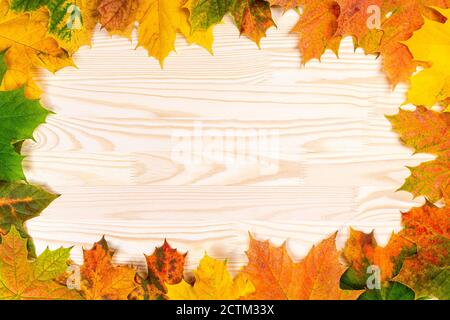 Seasonal autumn background. Frame of colorful maple leaves. Autumn Frame With Blowing Maple Leaves Over wooden vintage Background Stock Photo