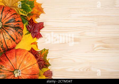 Autumn composition of fallen leaves of maple and pumpkins on wooden table, thanksgiving holiday party background. flatlay Stock Photo