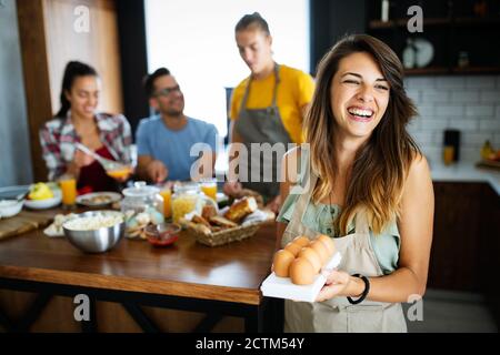 Beautiful happy people, friends is smiling while cooking together in the kitchen Stock Photo