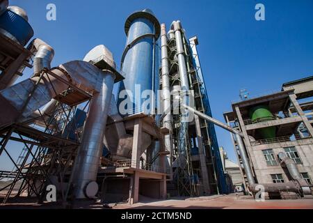 Mynaral/Kazakhstan - April 23 2012: Modern Jambyl Cement plant. The silo, tubes and gray factory building on the blue sky. Panorama view with wide-ang Stock Photo