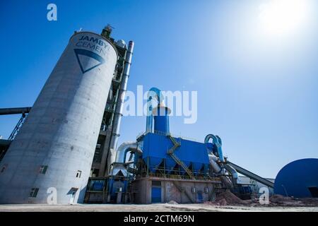 Mynaral/Kazakhstan - April 23 2012: Modern Jambyl Cement plant. Tower (silo) on blue sky with sun. Wide-angle lens panorama view. Stock Photo