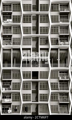 A modern apartment block with hexagonal honeycomb designs on the facade of balconies and windows. Stock Photo
