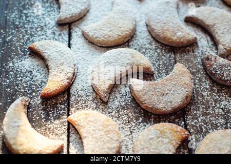 Shortbread New Year's, Christmas cookies in the shape of the moon. A child sprinkles cookies with powdered sugar. Baby and cookies. Child's hands in Stock Photo