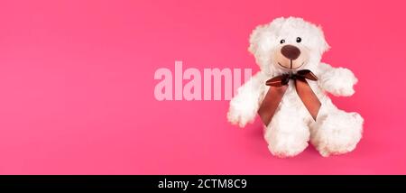 Teddy bear furry toy for kids isolated on pink background. Cheerful posotive romantic bear. Stock Photo