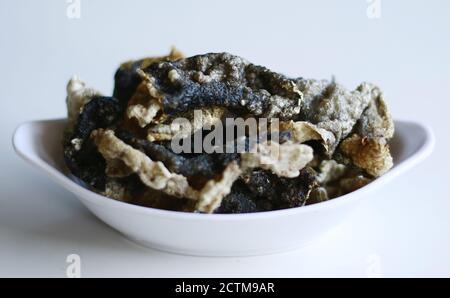 Fish skin crackers on white background. Made from patin fish. Stock Photo