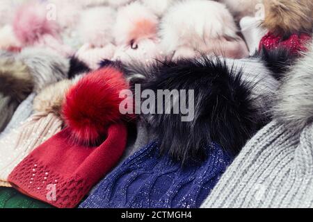 Rows of colorful wool hats with fluffy pom poms Stock Photo