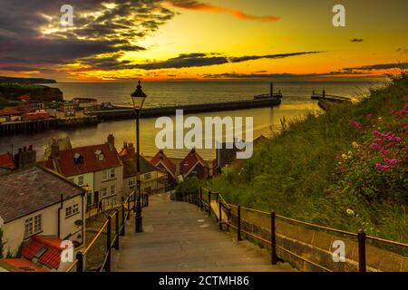 199 steps leading from the abbey down to Whitby harbour. Warm colours in the sky at sunset. Yorkshire tourist destination Stock Photo