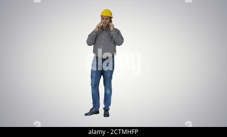 Construction worker using smartphone on gradient background. Stock Photo