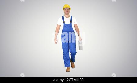 Carpenter walking on gradient background. Stock Photo