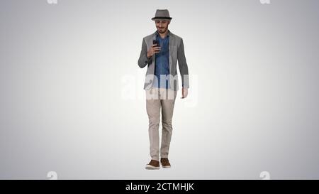 Smart casual arabian man using smartphone while walking on gradi Stock Photo
