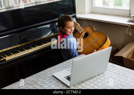 little girl holding a broken guitar, guitar repair Stock Photo