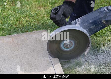 Closeup of an industrial construction worker using a professional angle grinder Stock Photo