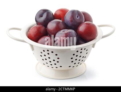 fresh ripe plums in white colander isolated on white background Stock Photo