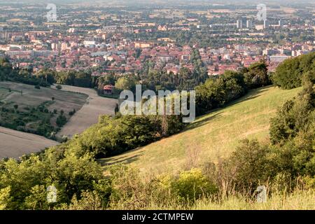 Panoramic view of Bologna from Bolognese hills. The city in background with rural fields and wheat in close up. Evening moment, almost at sunset Emili Stock Photo