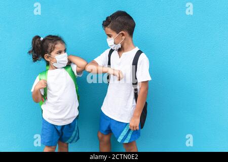 Children bump their elbows instead of greeting with a hug - Avoid the spread of coronavirus, social distance and friendship concept Focus on male kid Stock Photo