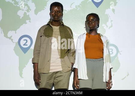 Portrait of young African-American man and woman standing against map by projector screen with numbers on it, copy space Stock Photo