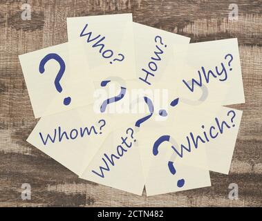 Adhesive notes with question marks on wood Stock Photo
