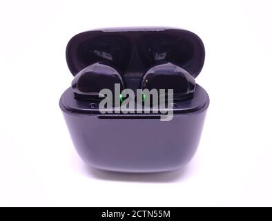 Black wireless headphone with case isolated on white background. Selective focus Stock Photo